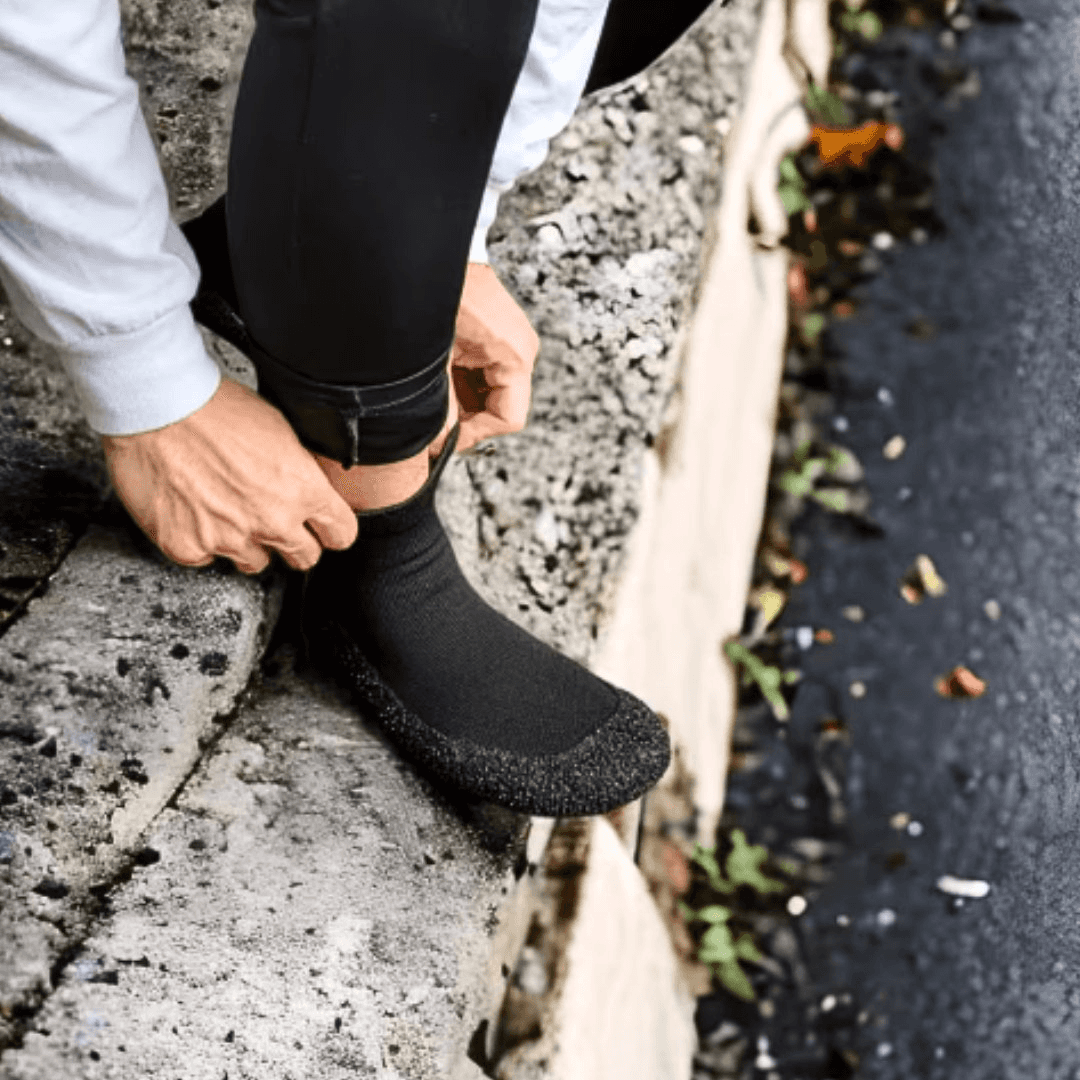 Person wearing DIRTS socks outdoors, adjusting fit